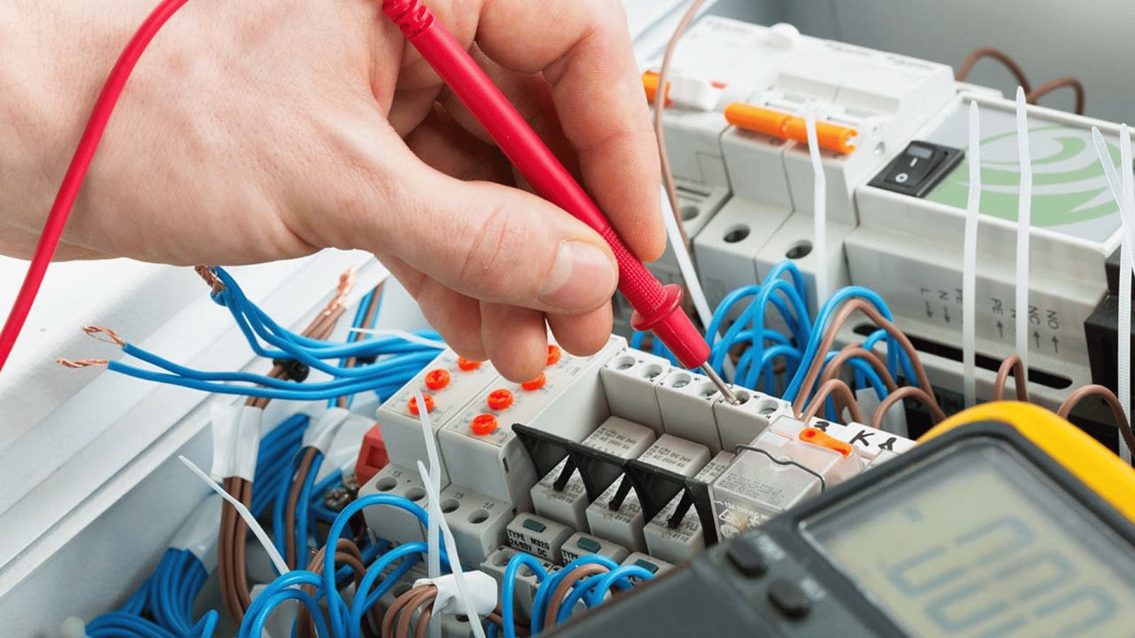 DH Electrical engineer testing a distribution board with a multimeter probe in Liverpool