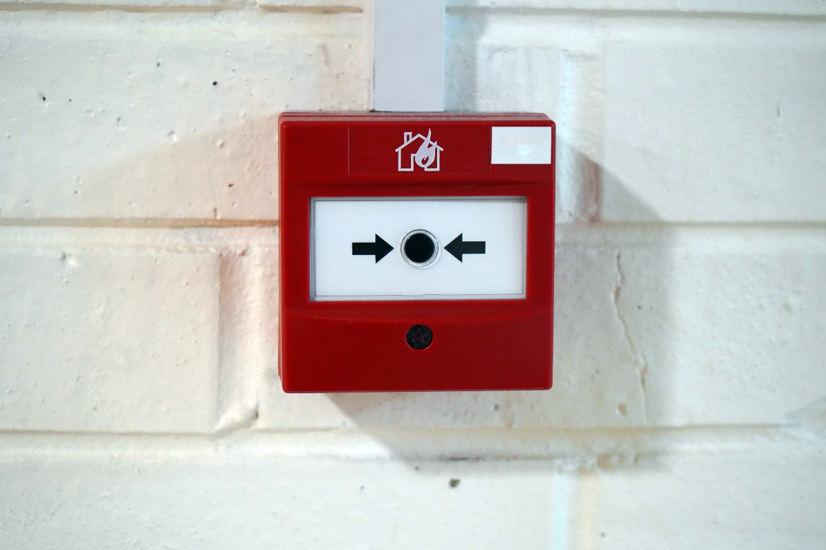 Red fire alarm call point tested by DH Electrical in Liverpool